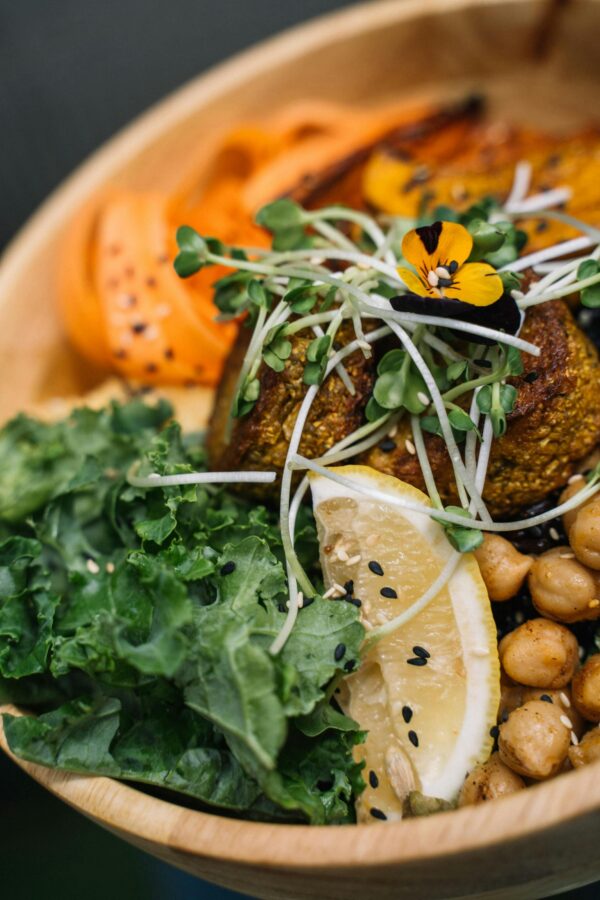 Vibrant vegan Buddha bowl featuring fresh veggies, chickpeas, and lemon slices.